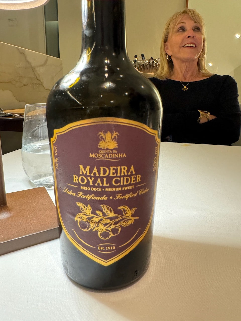 Bottle of cider from Madeira with Barbara Nevins Taylor in background.