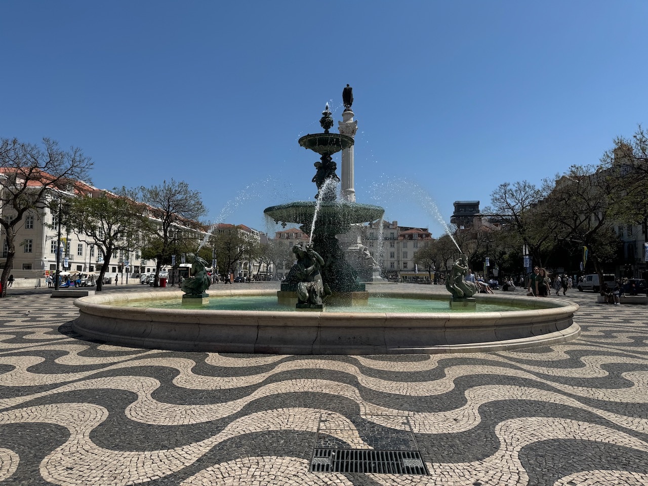 Fountain in Rossio Square with black and white tile that looks wavy