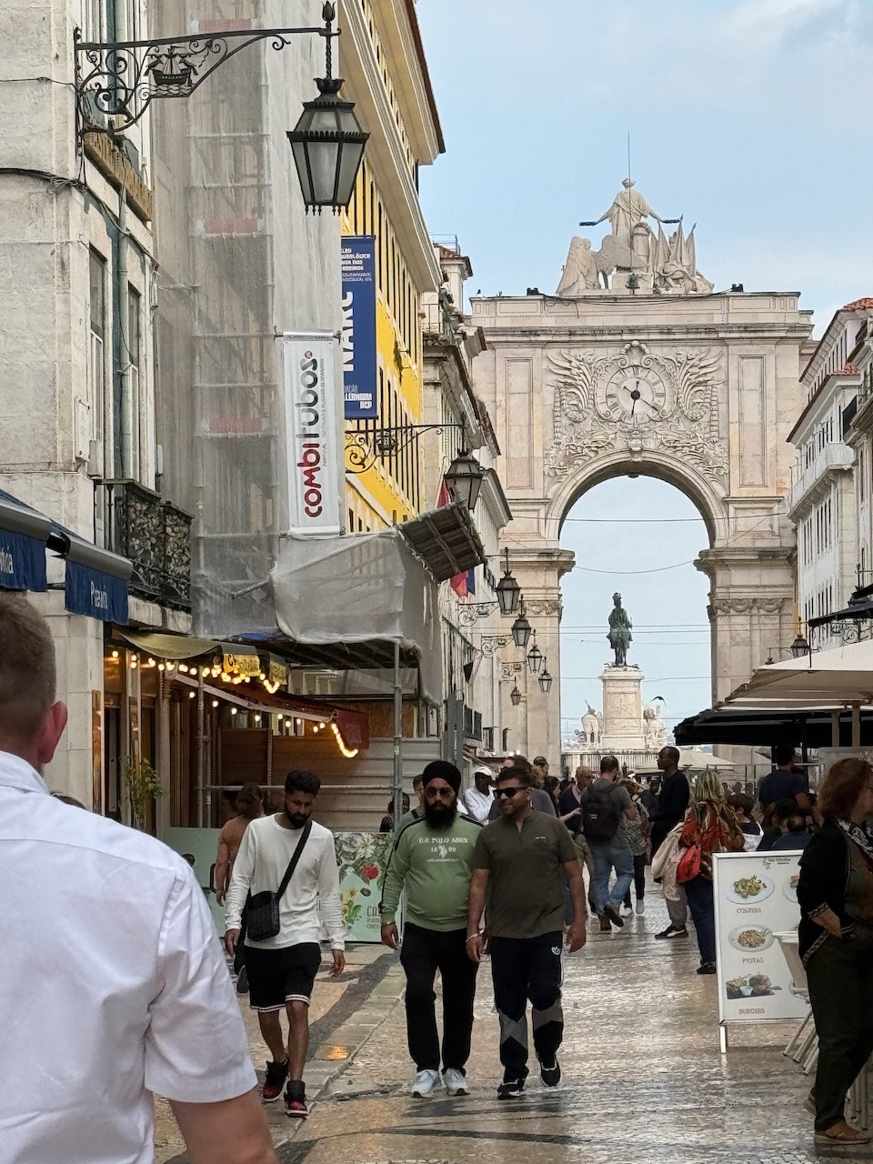 People walking on the Rua Augusta and the arch in the background