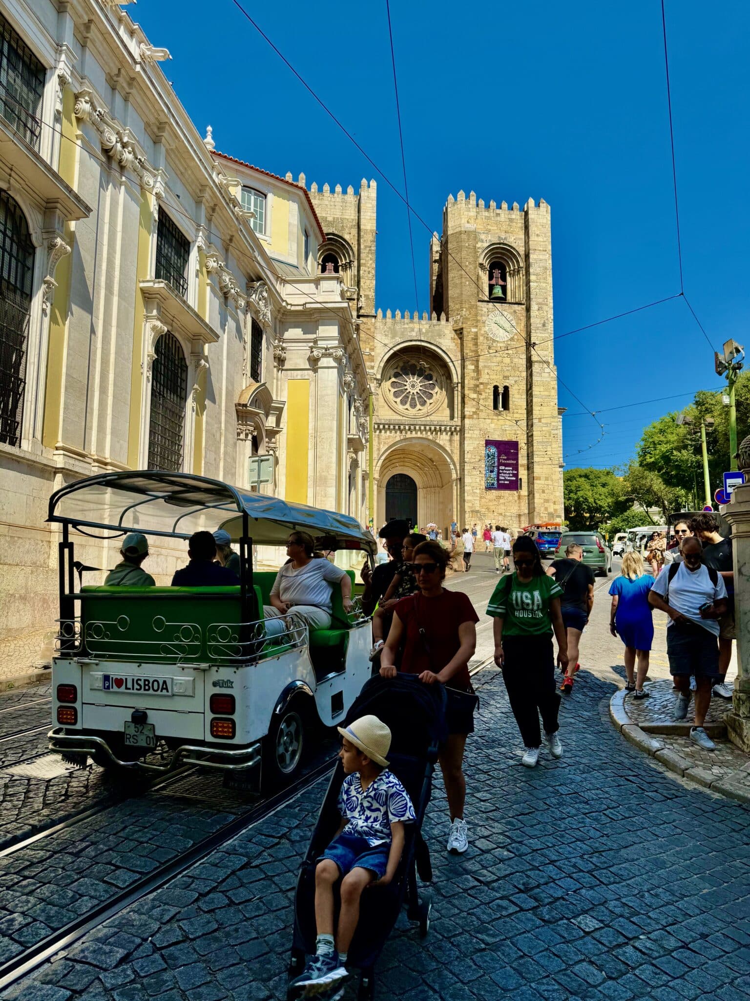 Tourists and a church in the Alfama neighborhood of Lisbon, Portugal.